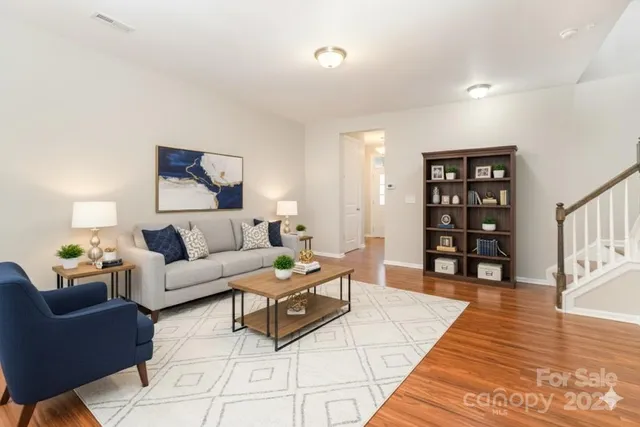 a living room with furniture and wooden floor