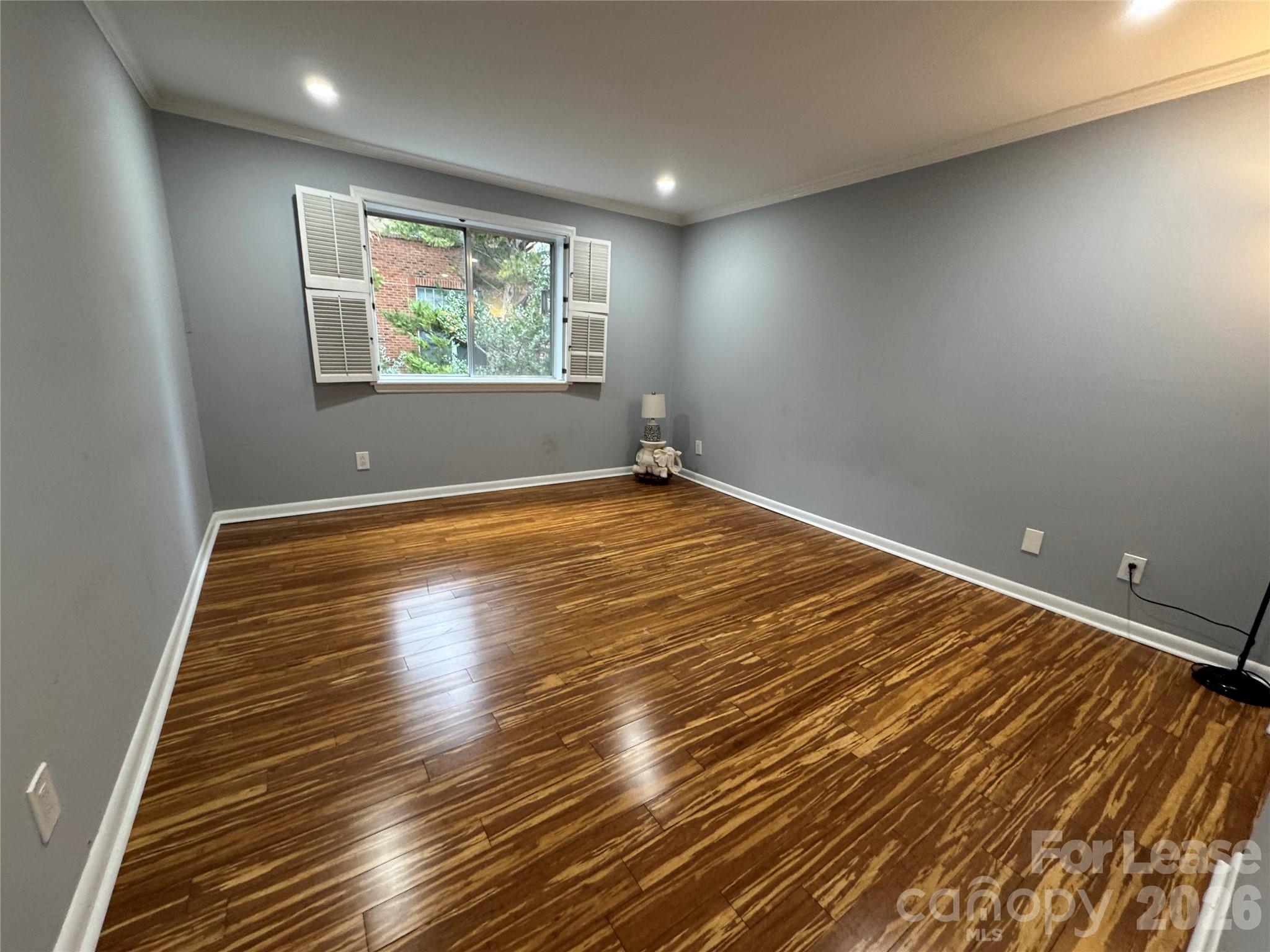 1323 Queens Road, Unit 303 Charlotte, NC 28207 - Photo 15 of 47 an empty room with wooden floor and windows