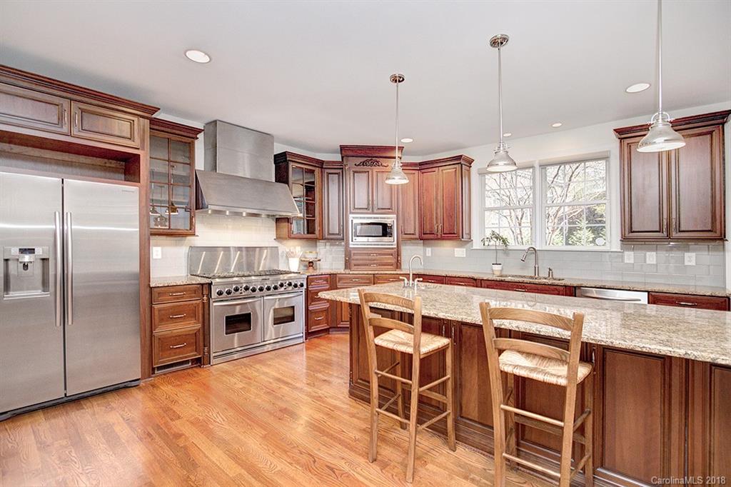2511 Sharon Road Charlotte, NC 28211 - Photo 8 of 27 a kitchen with stainless steel appliances granite countertop a stove refrigerator and cabinets