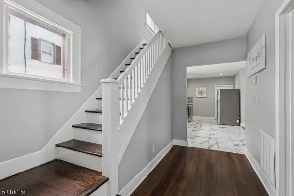 a view of entryway and hall with wooden floor