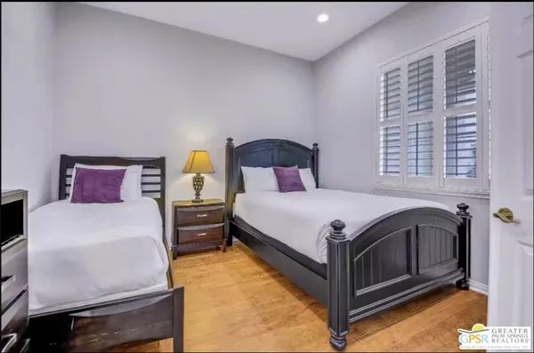 a bedroom with two beds and a flat screen tv