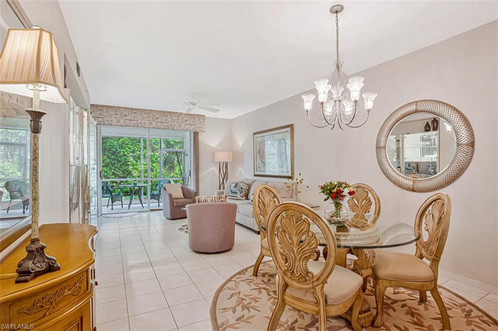 6605 Huntington Lakes Circle, Unit 103 Naples, FL 34119 - Photo 11 of 30 a living room with furniture chandelier and a large window