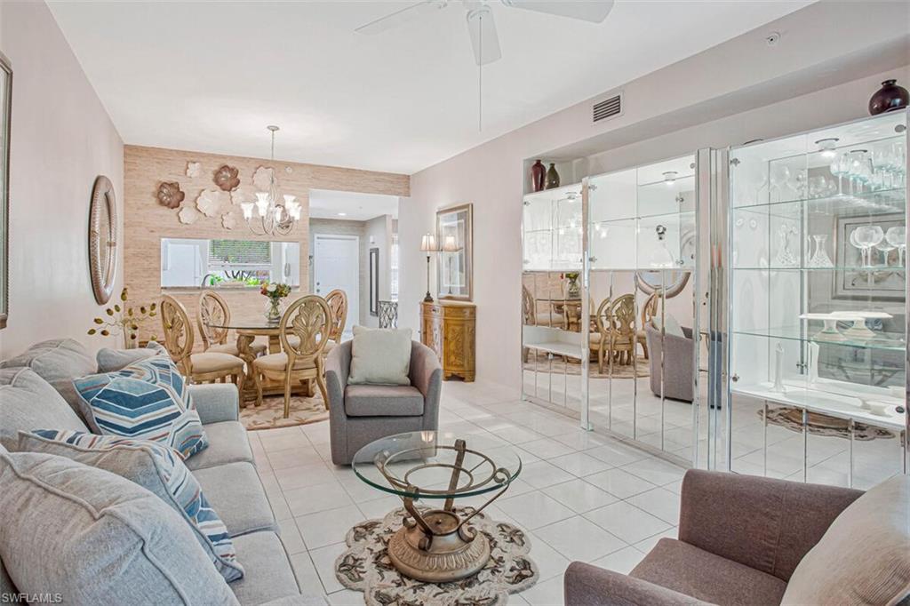 6605 Huntington Lakes Circle, Unit 103 Naples, FL 34119 - Photo 13 of 30 a living room with furniture and a large window