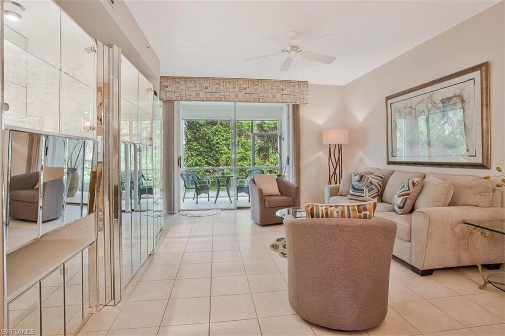 6605 Huntington Lakes Circle, Unit 103 Naples, FL 34119 - Photo 14 of 30 a living room with furniture and a large window