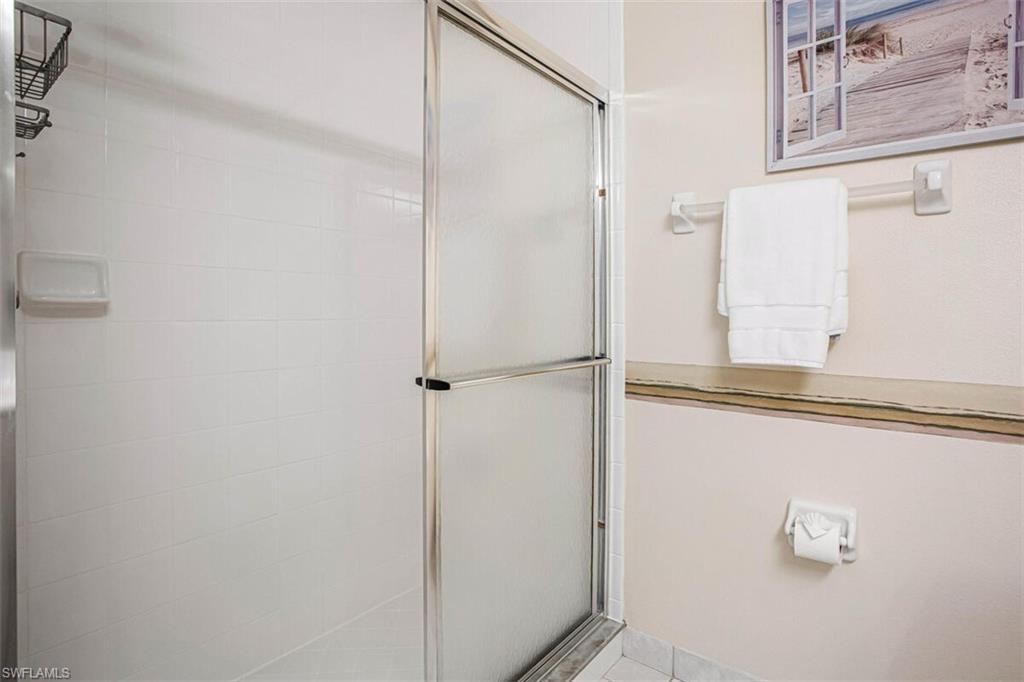 6605 Huntington Lakes Circle, Unit 103 Naples, FL 34119 - Photo 19 of 30 a bathroom with a glass shower door