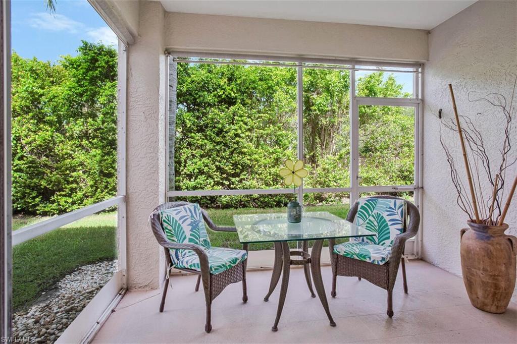 6605 Huntington Lakes Circle, Unit 103 Naples, FL 34119 - Photo 25 of 30 a dining room with furniture and garden view