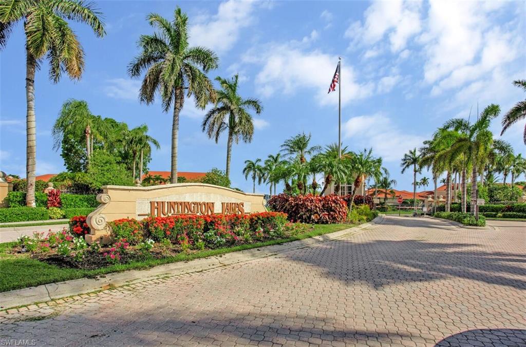 6605 Huntington Lakes Circle, Unit 103 Naples, FL 34119 - Photo 28 of 30 a front view of a house with garden and trees