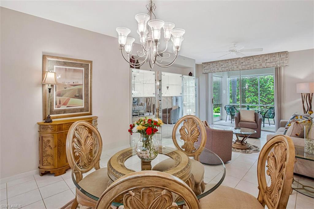 6605 Huntington Lakes Circle, Unit 103 Naples, FL 34119 - Photo 9 of 30 a view of a livingroom with furniture window wooden floor and a mirror