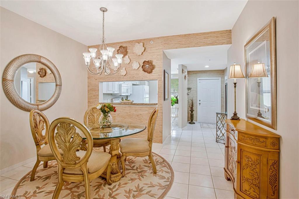 6605 Huntington Lakes Circle, Unit 103 Naples, FL 34119 - Photo 10 of 30 a dining room with furniture and a chandelier