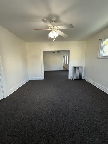 a view of a livingroom with a ceiling fan and window