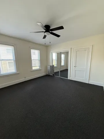 a view of a livingroom with a ceiling fan and window