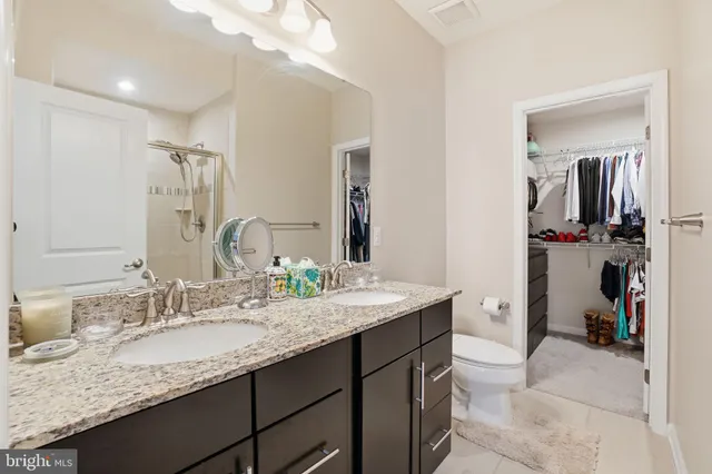 a bathroom with a granite countertop sink double vanity and a mirror