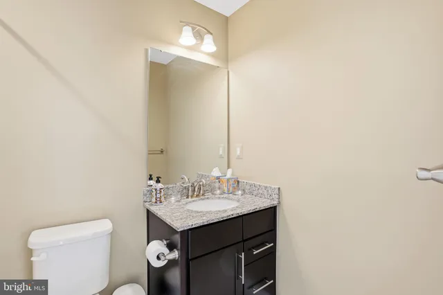 a bathroom with a toilet a sink and mirror
