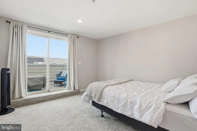 a bedroom with a bed and a large window