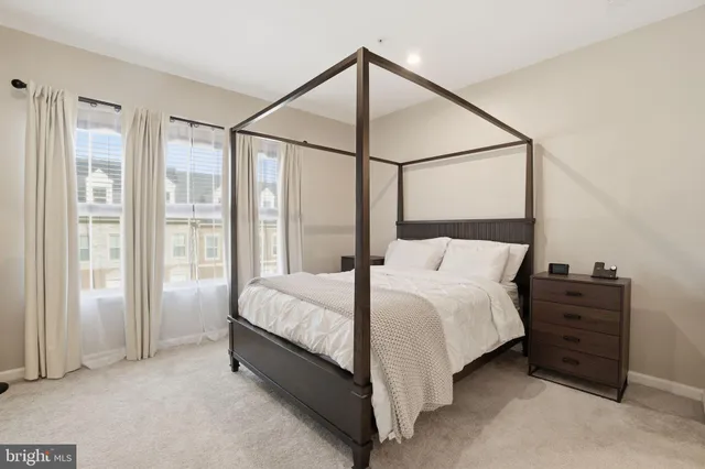 a bedroom with a bed and a dresser next to a window