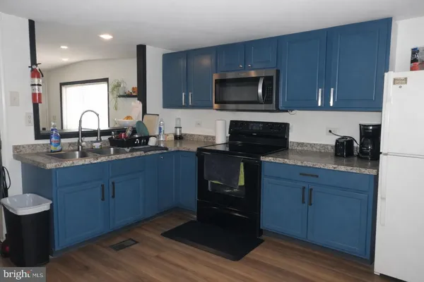 a kitchen with stainless steel appliances kitchen island granite countertop a stove a sink and a microwave