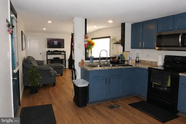 a kitchen with granite countertop a stove and a microwave