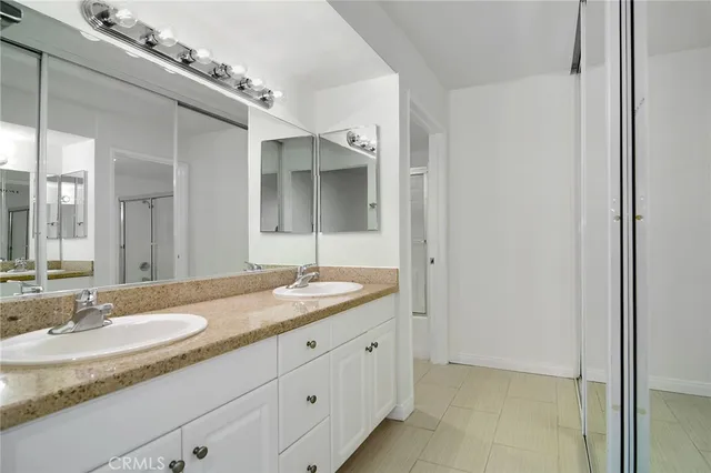 a bathroom with a granite countertop sink double and mirror