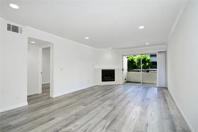 a view of an empty room with a fireplace and a window