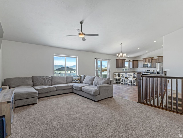 573 South Maxwell Drive Grantsville, UT 84029 - Photo 5 of 25 Living area with a chandelier, a ceiling fan, dark colored carpet, and lofted ceiling