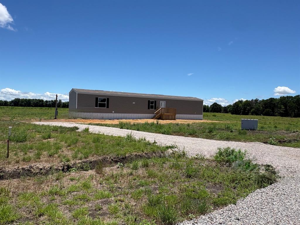 0 Southeast 4060 Road, Unit 25 Kerens, TX 75144 - Photo 2 of 18 Manufactured home featuring neutral-toned siding, dark window shutters, and a light-colored foundation