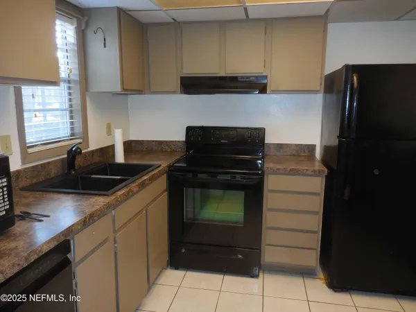 a kitchen with granite countertop a refrigerator and a sink
