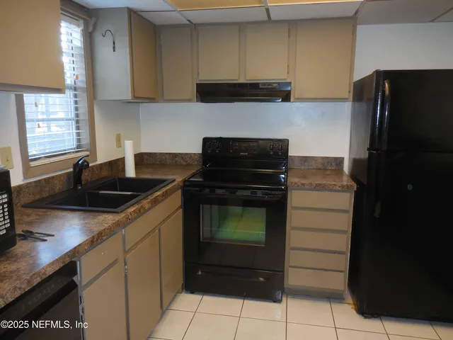 a kitchen with granite countertop a refrigerator and a sink
