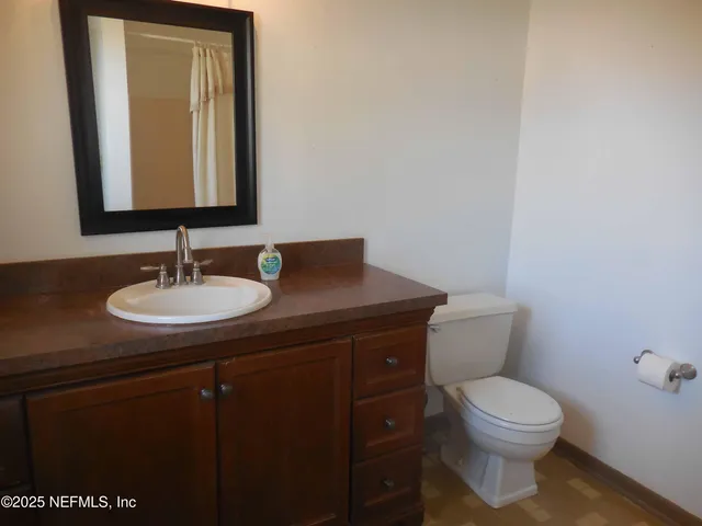 a bathroom with a toilet a sink and mirror