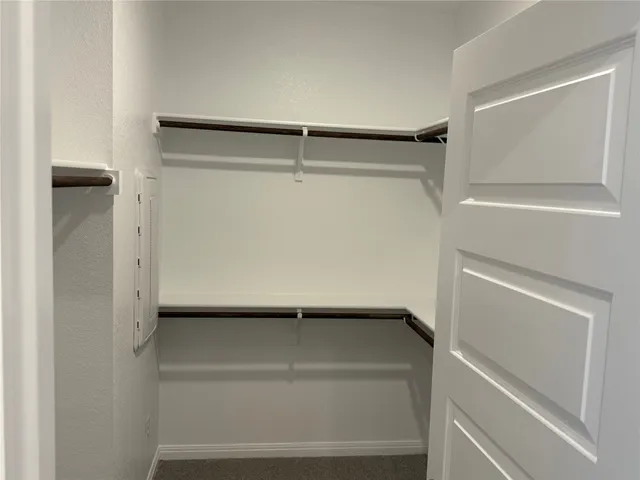 a view of walk in closet with empty racks