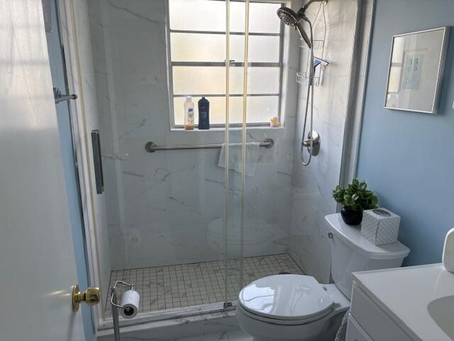 313 Dorset H, Unit 313 Boca Raton, FL 33434 - Photo 11 of 20 a white toilet sitting next to a bathroom sink