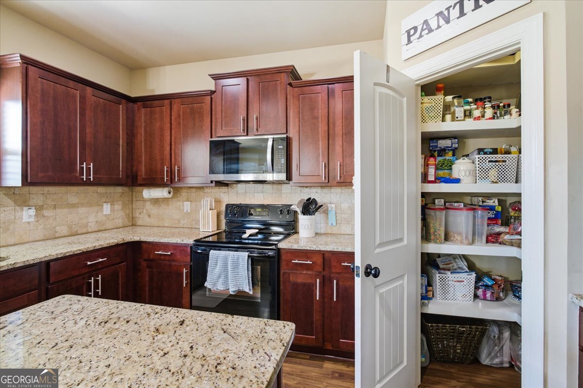 440 Creekside Park Covington, GA 30014 - Photo 14 of 57 a kitchen with stainless steel appliances a stove top oven a sink and cabinets