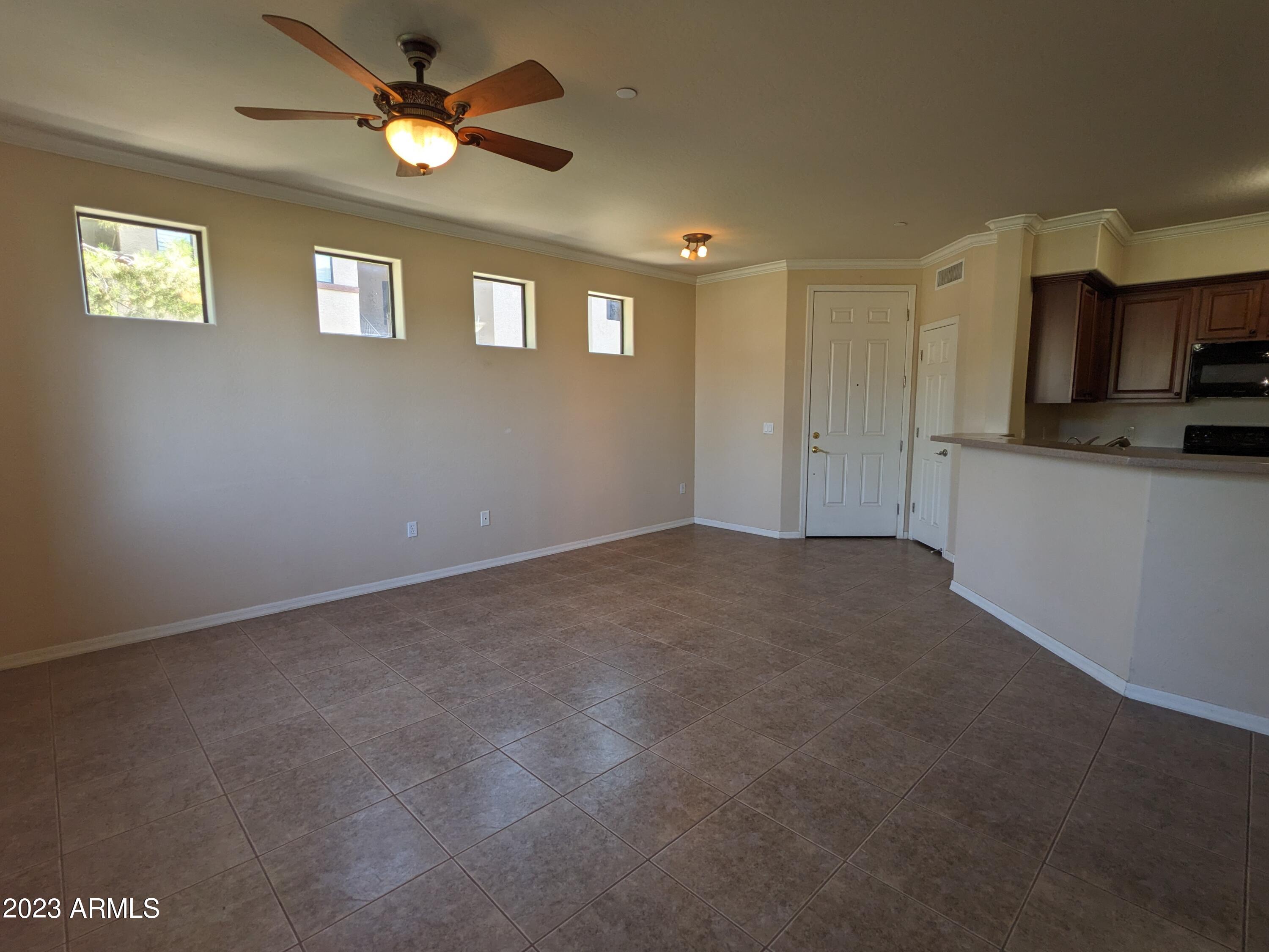 3330 South Gilbert Road, Unit 1007 Chandler, AZ 85286 - Photo 6 of 12 a view of a kitchen with a sink a ceiling fan and wooden floor
