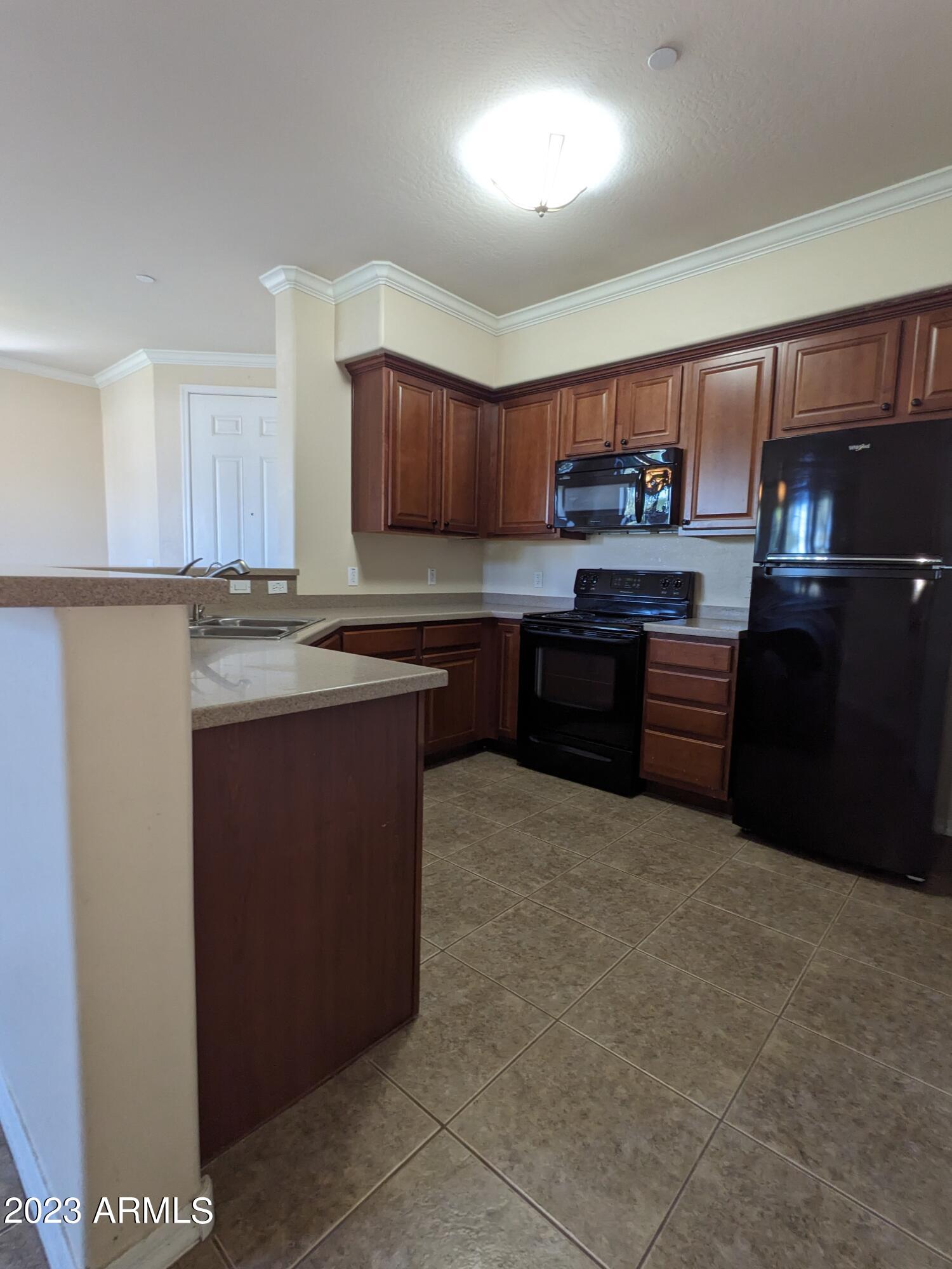 3330 South Gilbert Road, Unit 1007 Chandler, AZ 85286 - Photo 8 of 12 a kitchen with stainless steel appliances granite countertop a stove sink and cabinets