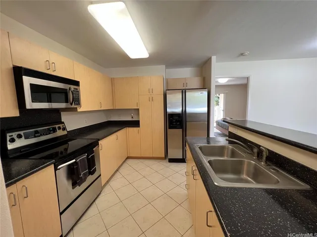 a kitchen that has a sink and a stove top oven