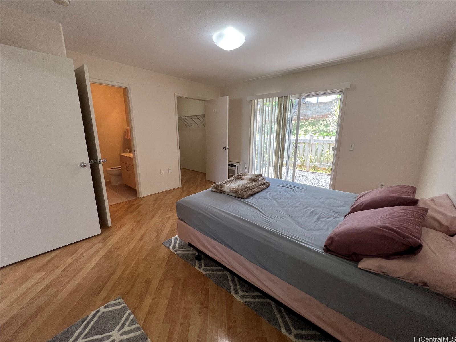 95-1145 Koolani Drive, Unit 100 Mililani, HI 96789 - Photo 7 of 9 a bedroom with a bed and wooden floor