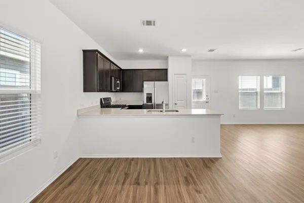 a large white kitchen with wooden floors and white walls