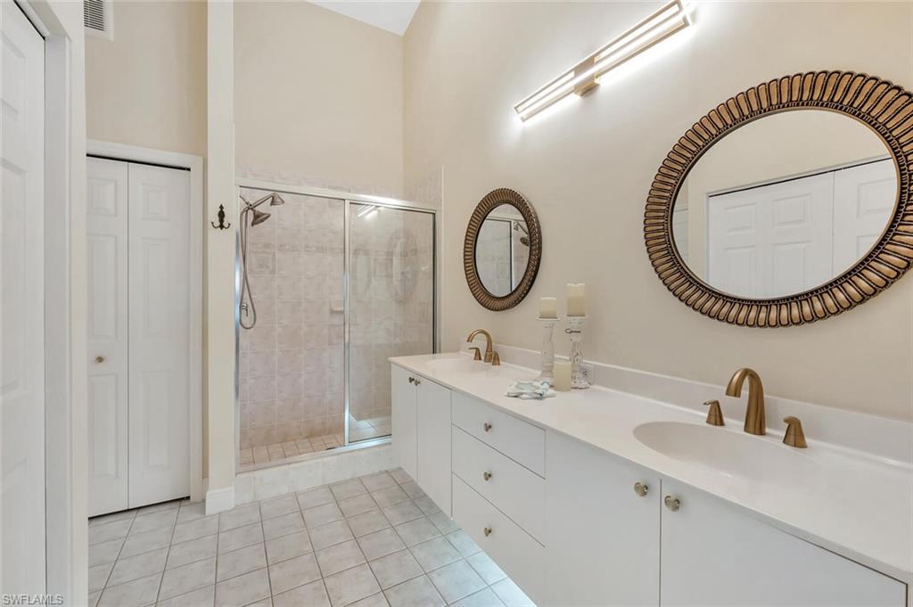 6720 Beach Resort Drive, Unit 10 Naples, FL 34114 - Photo 12 of 34 Full bath featuring a closet, a stall shower, double vanity, and tile patterned flooring
