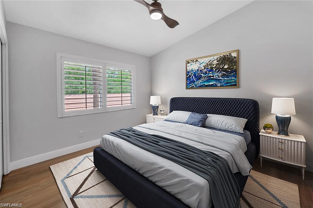 6720 Beach Resort Drive, Unit 10 Naples, FL 34114 - Photo 13 of 34 Bedroom featuring vaulted ceiling, wood finished floors, and ceiling fan. This photo is virtually staged.
