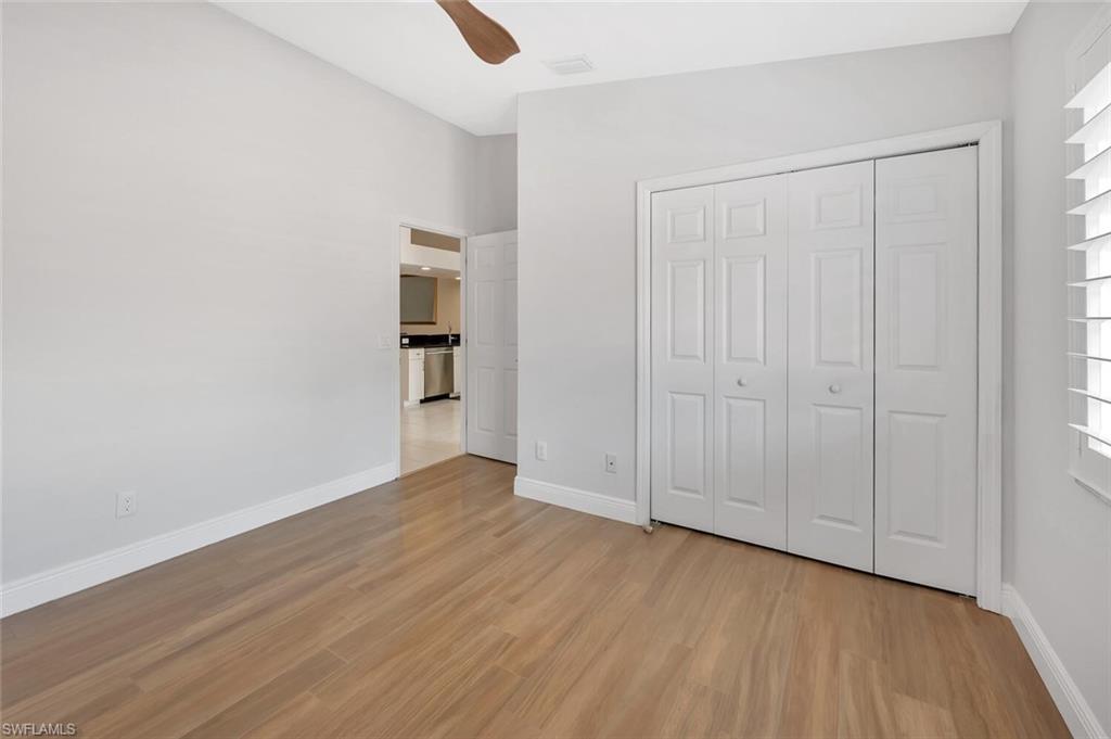 6720 Beach Resort Drive, Unit 10 Naples, FL 34114 - Photo 14 of 34 Unfurnished bedroom with light wood-type flooring, a closet, and a ceiling fan