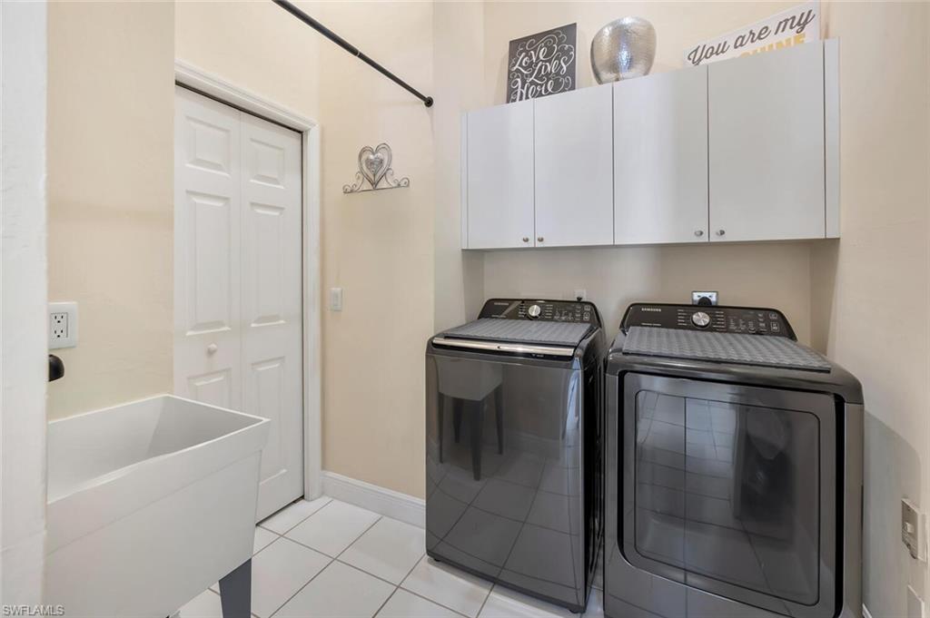 6720 Beach Resort Drive, Unit 10 Naples, FL 34114 - Photo 17 of 34 Laundry area featuring cabinet space, washer and clothes dryer, and light tile patterned flooring