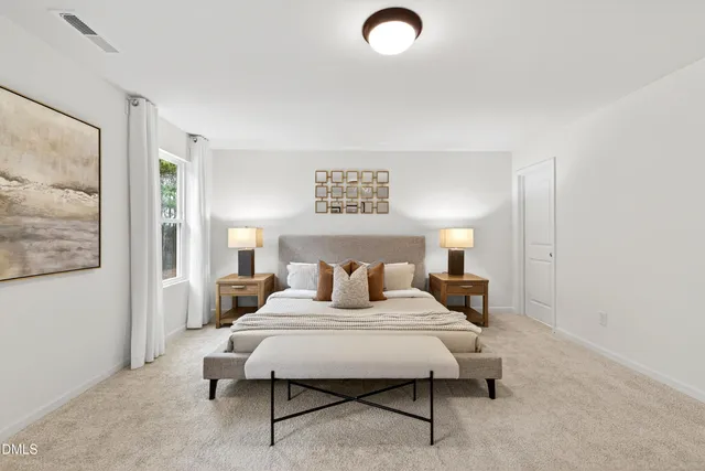 a bedroom with a bed and a lamp on dresser