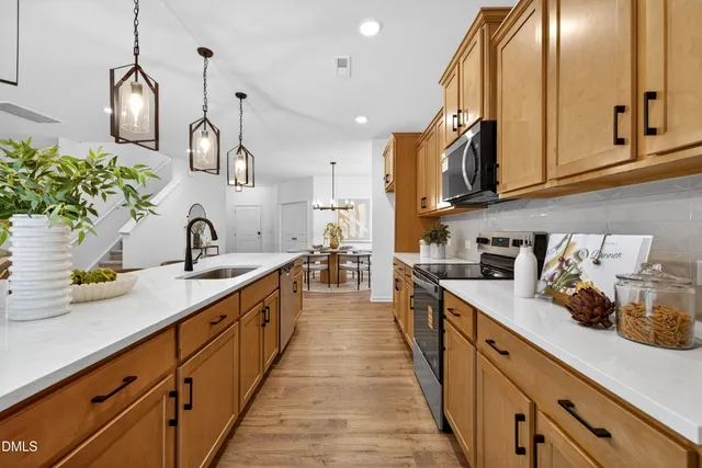 a large kitchen with stainless steel appliances lots of counter space and a sink