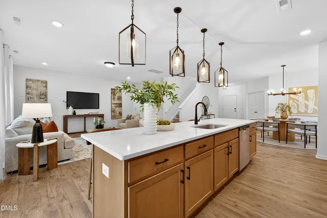 a kitchen with sink stove and flat screen tv