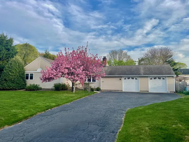 a view of a house with a big yard and a large tree