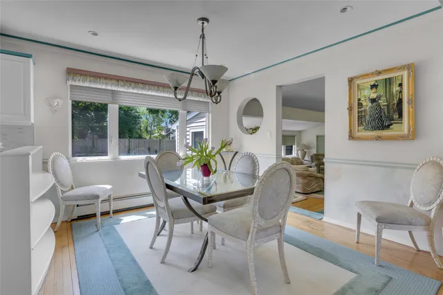 a dining room with furniture a chandelier and wooden floor