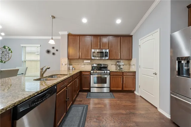 a large kitchen with granite countertop a stove sink and refrigerator