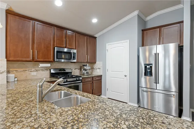 a kitchen with granite countertop a refrigerator stove and microwave