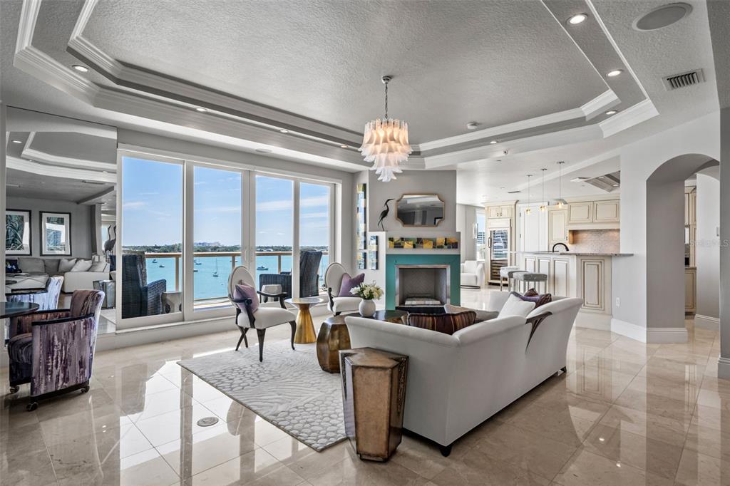 464 Golden Gate Point, Unit 703 Sarasota, FL 34236 - Photo 11 of 88 a living room with fireplace furniture and a chandelier