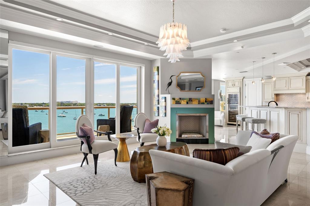 464 Golden Gate Point, Unit 703 Sarasota, FL 34236 - Photo 12 of 88 a living room with furniture chandelier and a fireplace