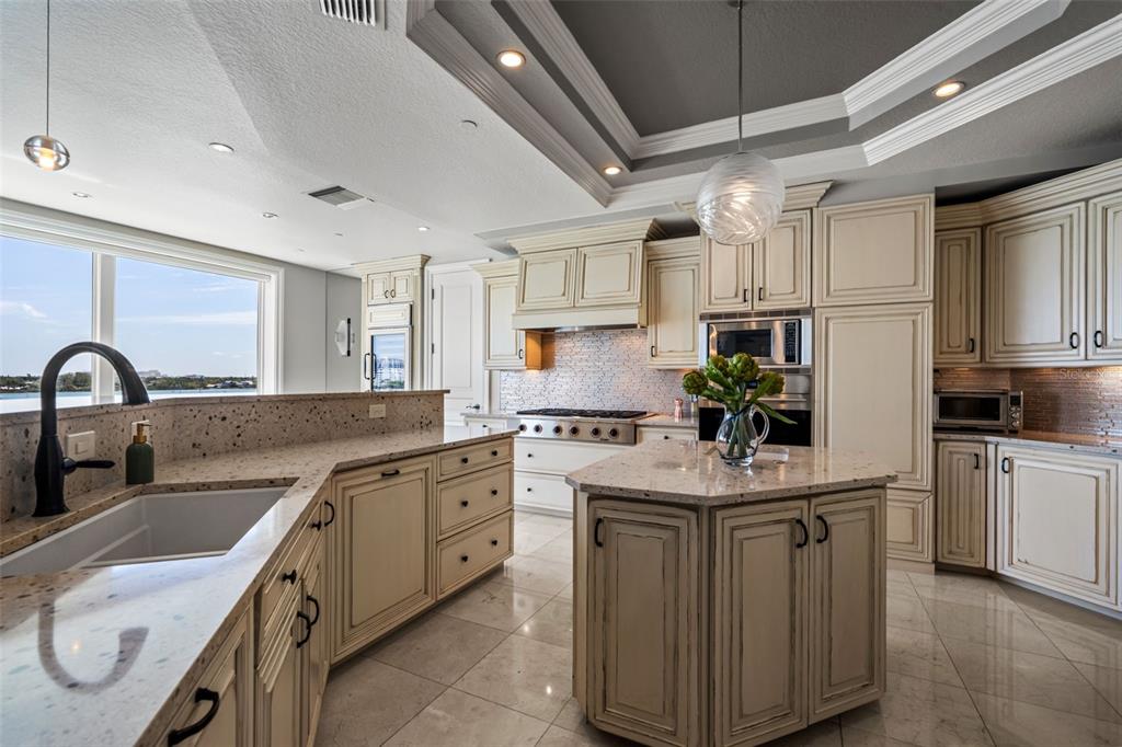 464 Golden Gate Point, Unit 703 Sarasota, FL 34236 - Photo 26 of 88 a kitchen with granite countertop a sink stainless steel appliances and white cabinets